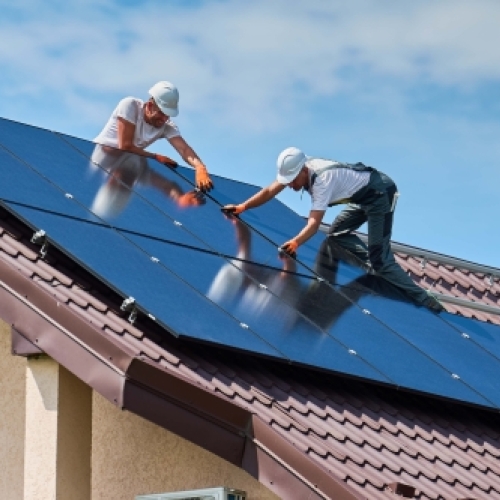 Montører installerer solceller på hustag